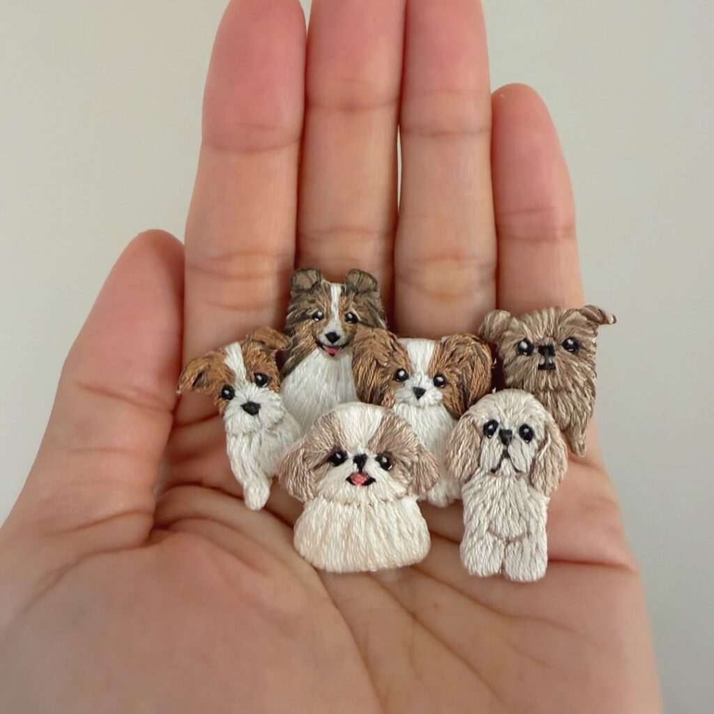 手のひらにのせたミニミニ刺繍の犬たち