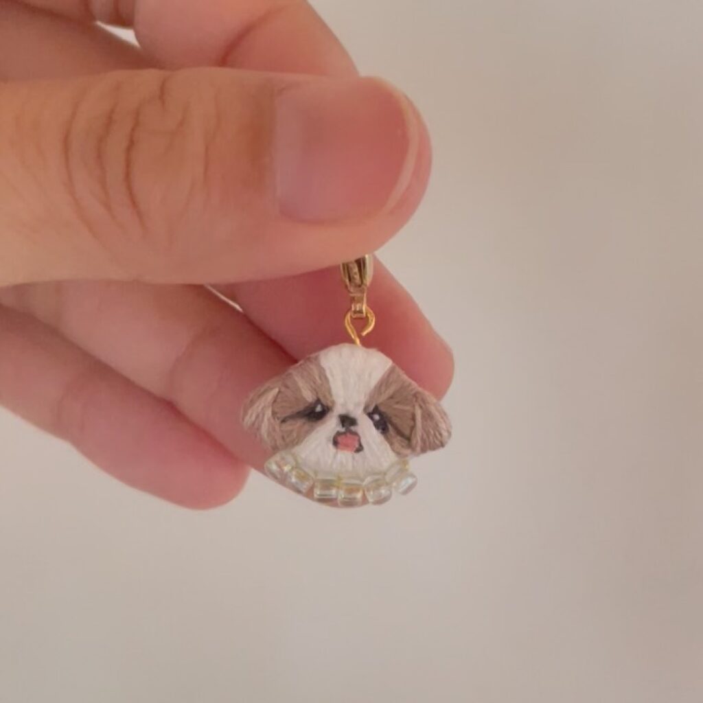 指でつまんだシーズーちゃんのお顔チャーム