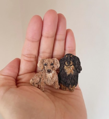 手のひらにのせたミニチュアダックス2ひきの刺繍ブローチ