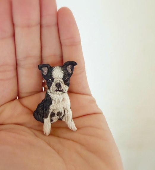 手のひらにのせたボストンテリアの刺繍ブローチ