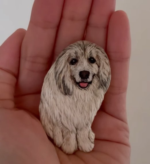 手のひらにのせたグレートピレニーズの刺繍ブローチ