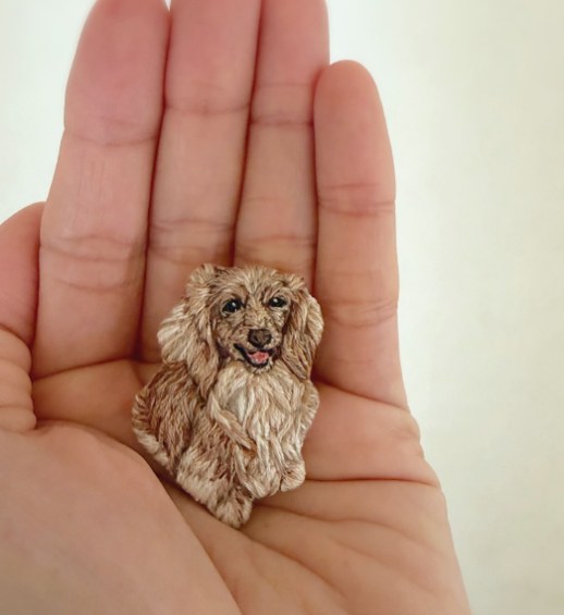 手のひらにのせたミニチュアダックスの刺繍ブローチ