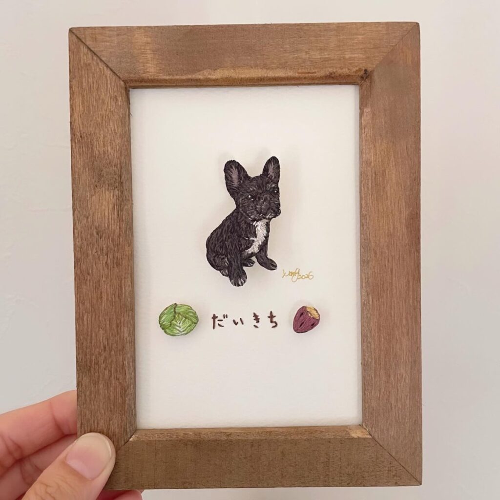 キャベツとさつまいもの刺繍と一緒に額に入れたフレンチブルドッグ