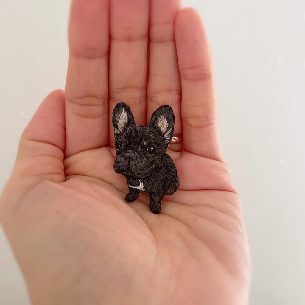 手のひらにのせたフレンチブルドッグの刺繍ブローチ